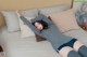 A woman laying on top of a bed with her legs up.