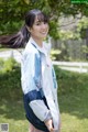 A woman in a blue and white jacket standing in the grass.