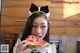 A woman in a maid outfit eating a slice of watermelon.