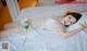 A woman laying on a bed in a white lingerie.