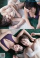 A couple of women laying on top of a green carpet.