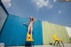 A woman in a bikini standing on a yellow chair.